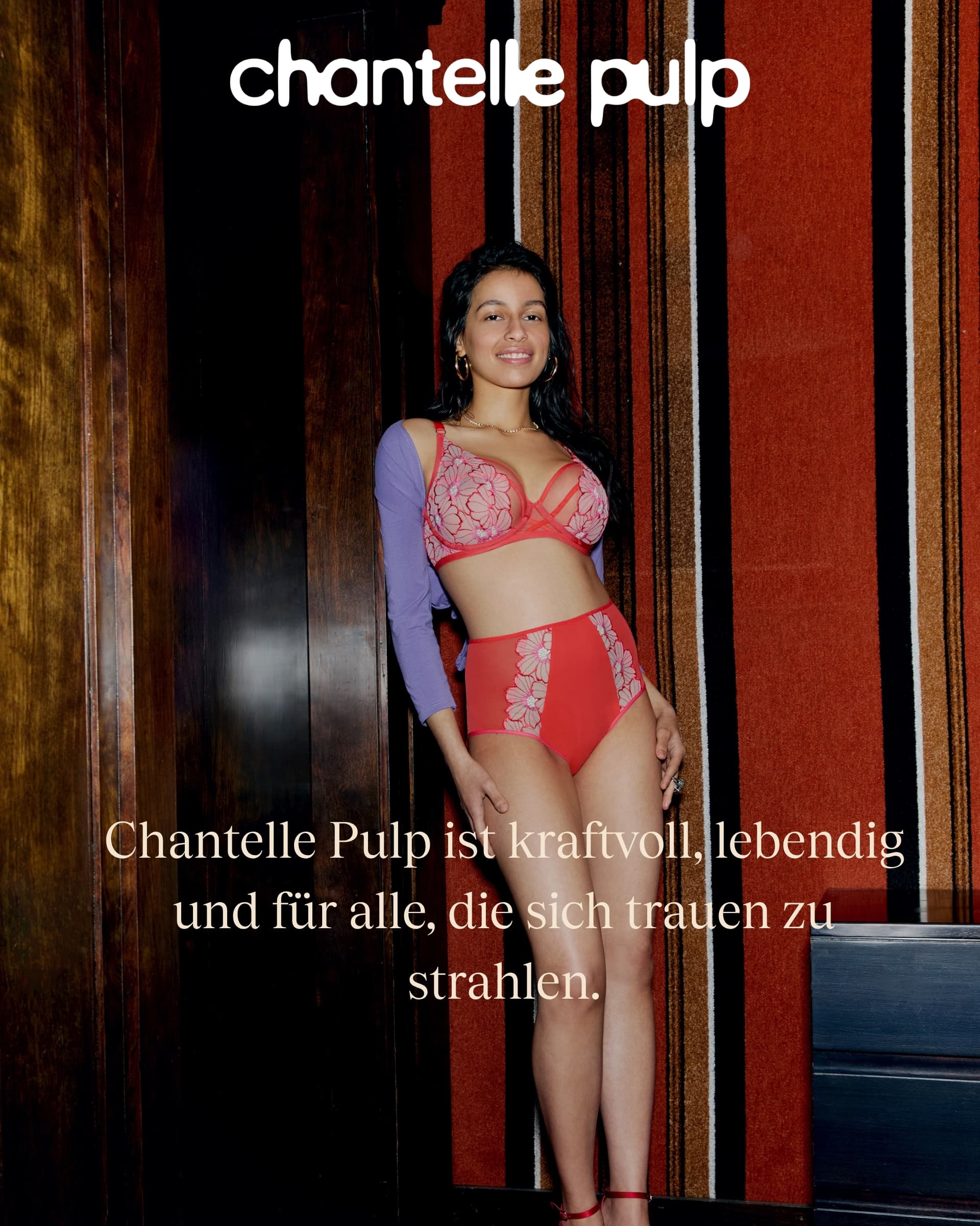 Woman in red lingerie and purple sleeves, standing near a colorful wall, with the text "Chantelle Pulp" and a message in German above.