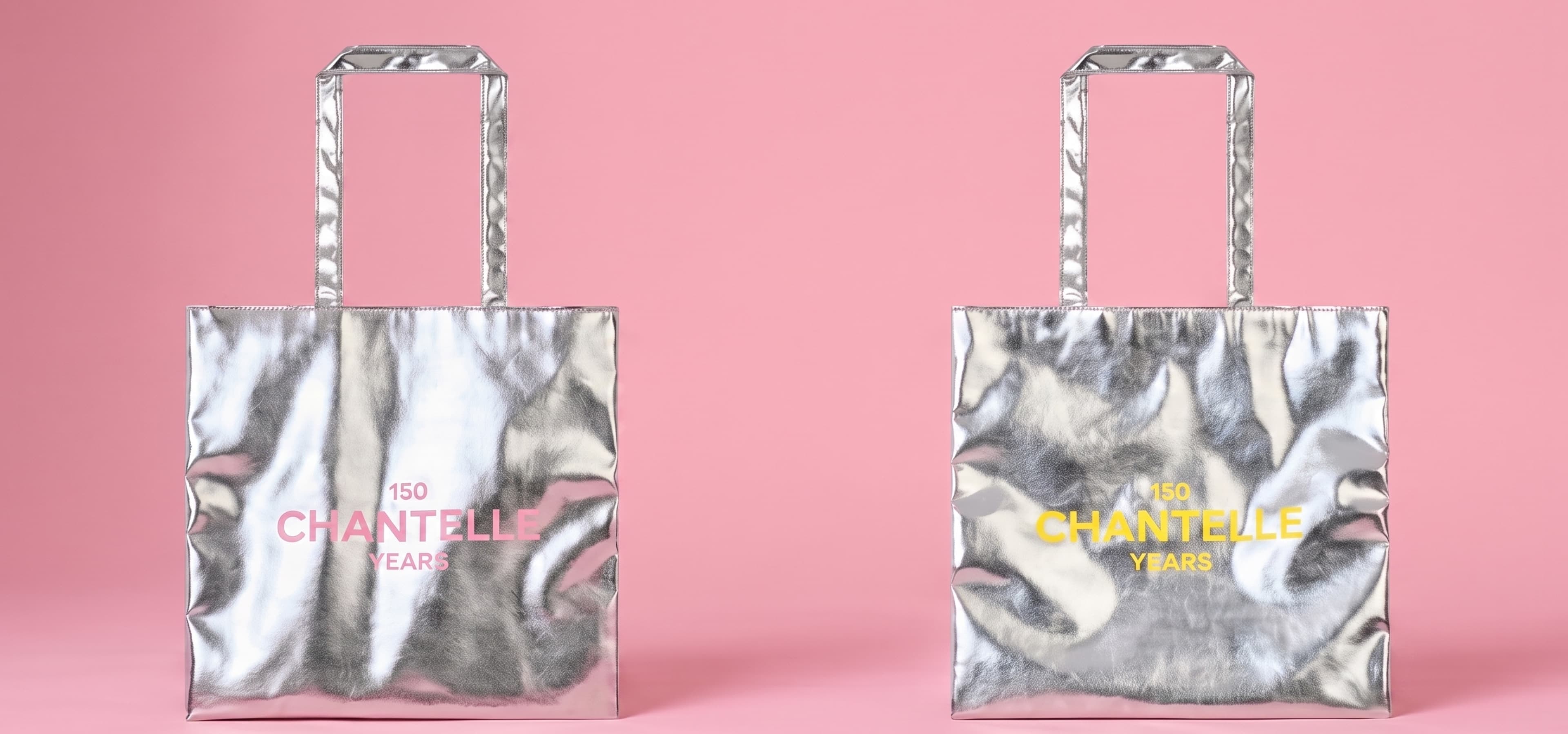 Two silver tote bags on a pink background, each with "150 Chantelle Years" printed in pink and yellow, respectively.