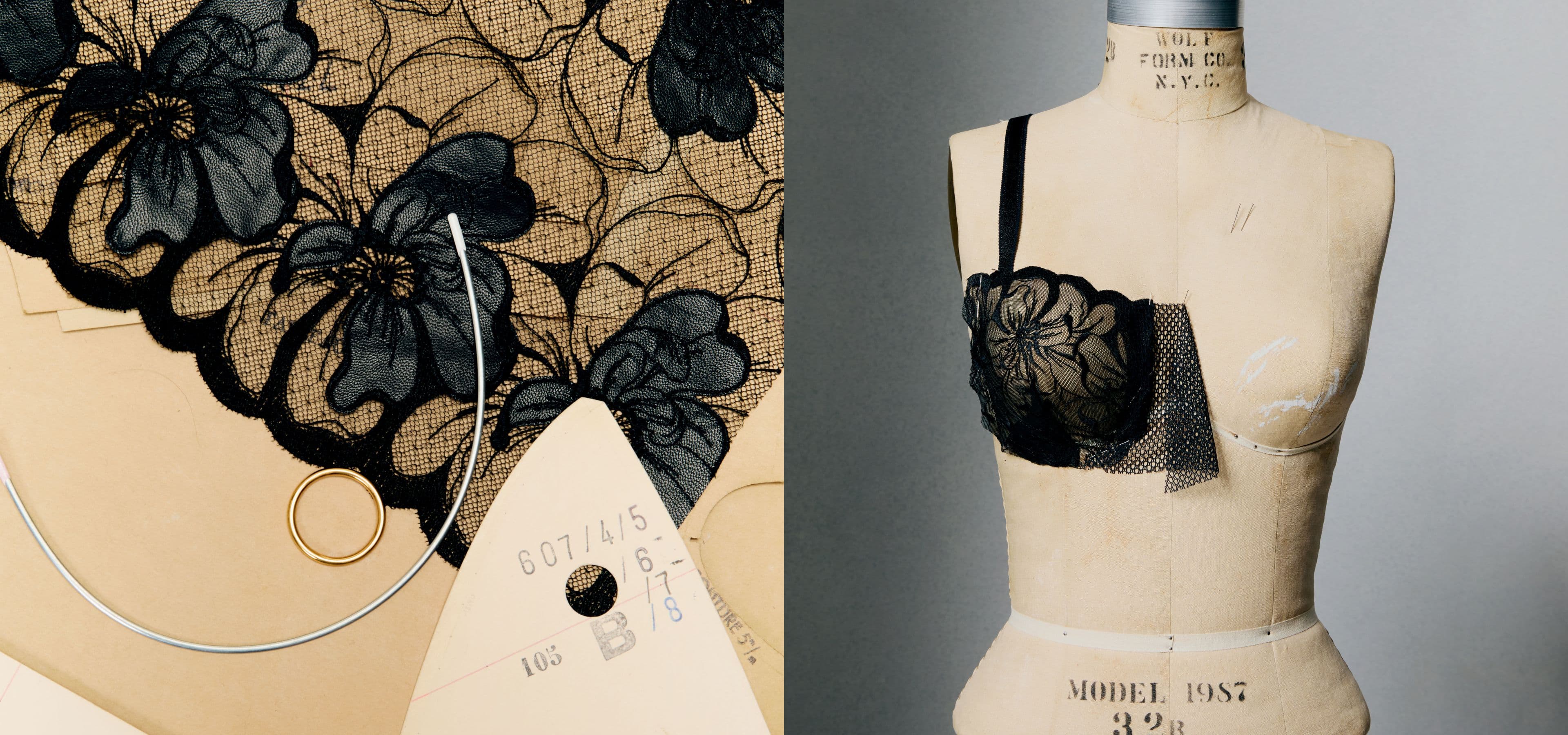 A vintage dress form displays a partially sewn, intricate black lace bustier next to sewing patterns and tools on a table.