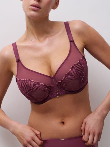 Person wearing a burgundy bra with floral embroidery and matching bottoms, posing against a plain background.
