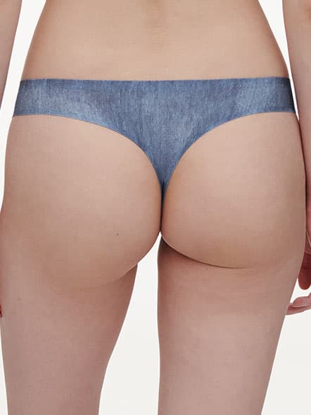 Back view of a person wearing blue denim-patterned thong underwear against a plain background.