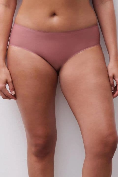 Person wearing mauve seamless underwear, showing a focus on comfort and fit. White background enhances the garment's color and texture.