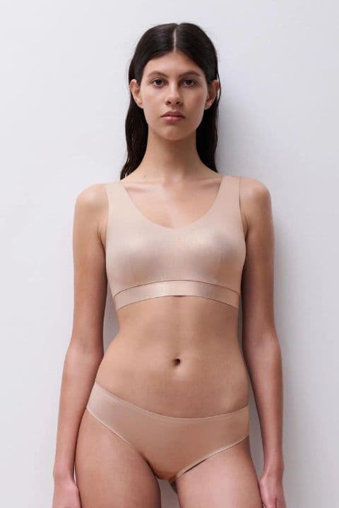 Person wearing a matching golden glow bra and panties set, standing against a plain white background.
