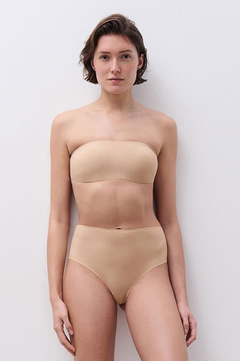 Frau im beigen SoftStretch Bandeau BH und dem passenden Unterteil