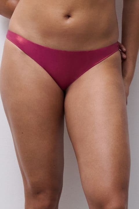 Person wearing pink bikini bottoms against a plain white background, showcasing the fit and fabric texture.