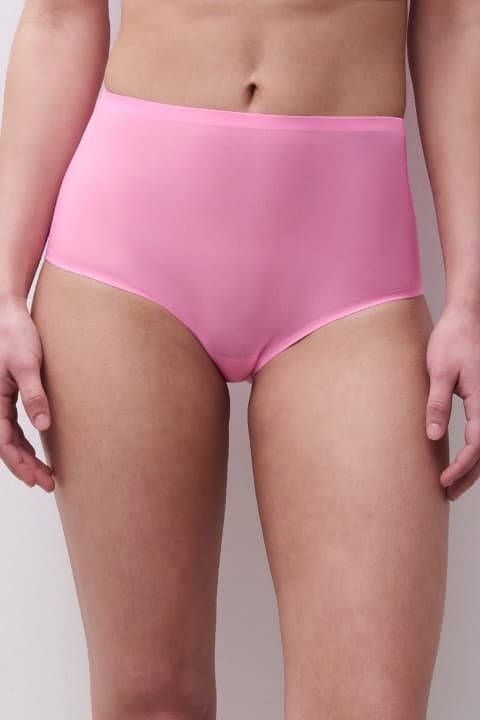 Person wearing high-waisted pink underwear, showcasing a simple and smooth design against a neutral background.