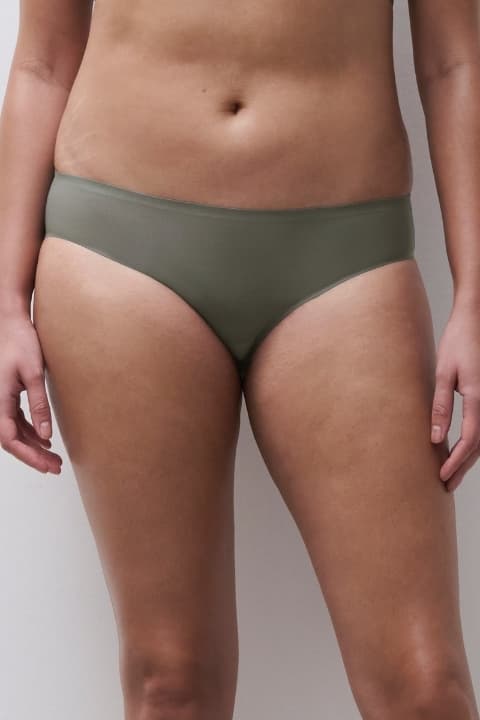 Person wearing olive green underwear, midriff visible against a neutral background.
