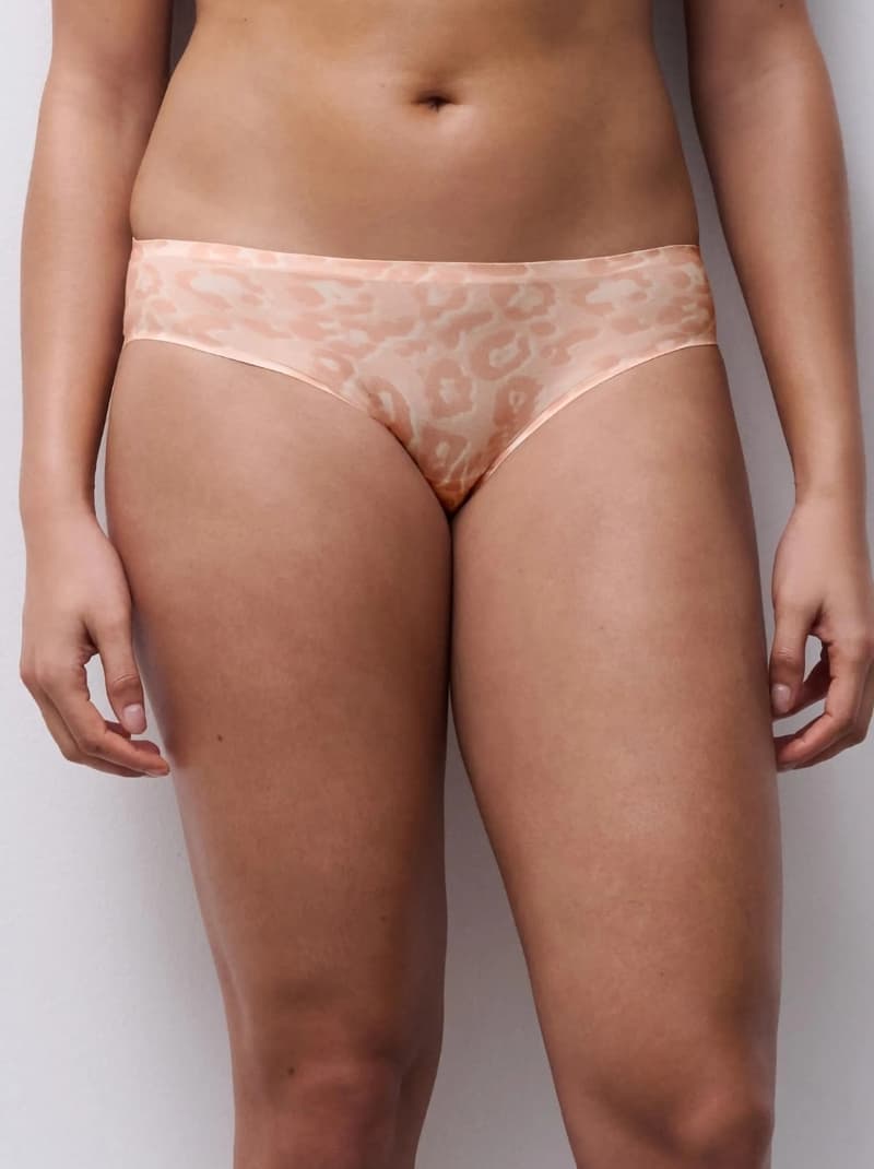 Person wearing seamless, peach-colored leopard print underwear, standing against a light background.