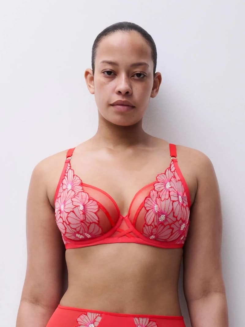 Person wearing a red floral-patterned bra, standing against a plain white background.