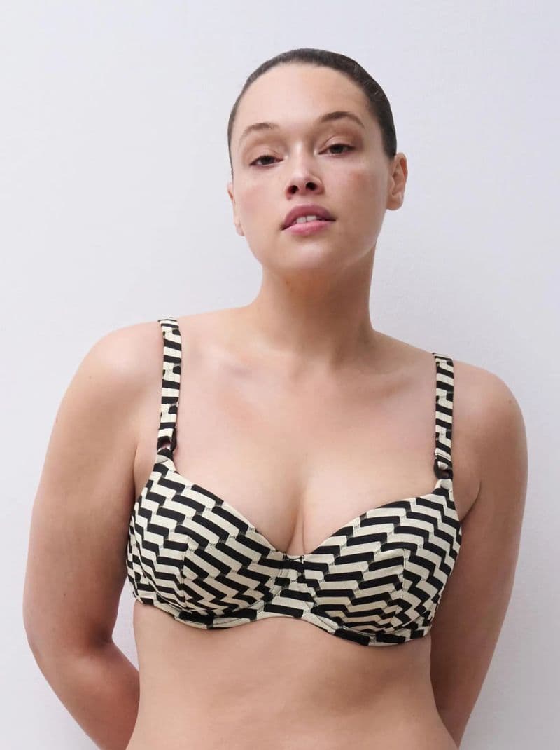 Person wearing a black and white chevron-patterned bra, standing against a plain white background.