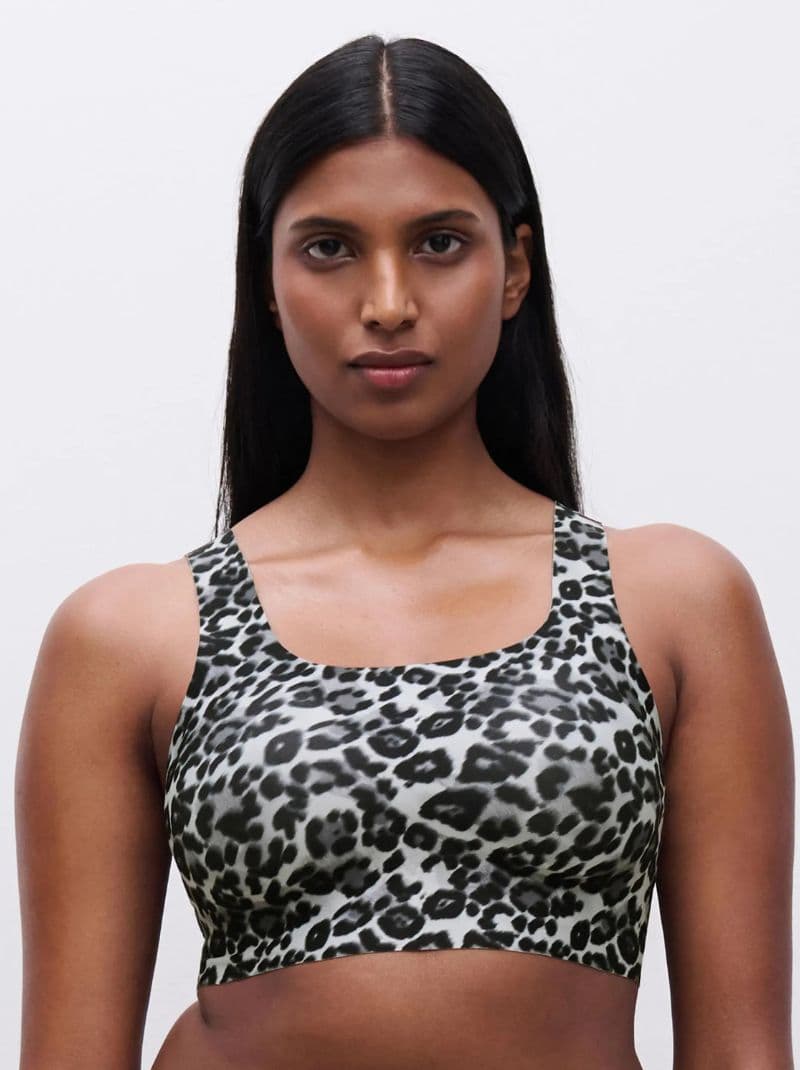 Person wearing a leopard print bra, standing against a plain background.