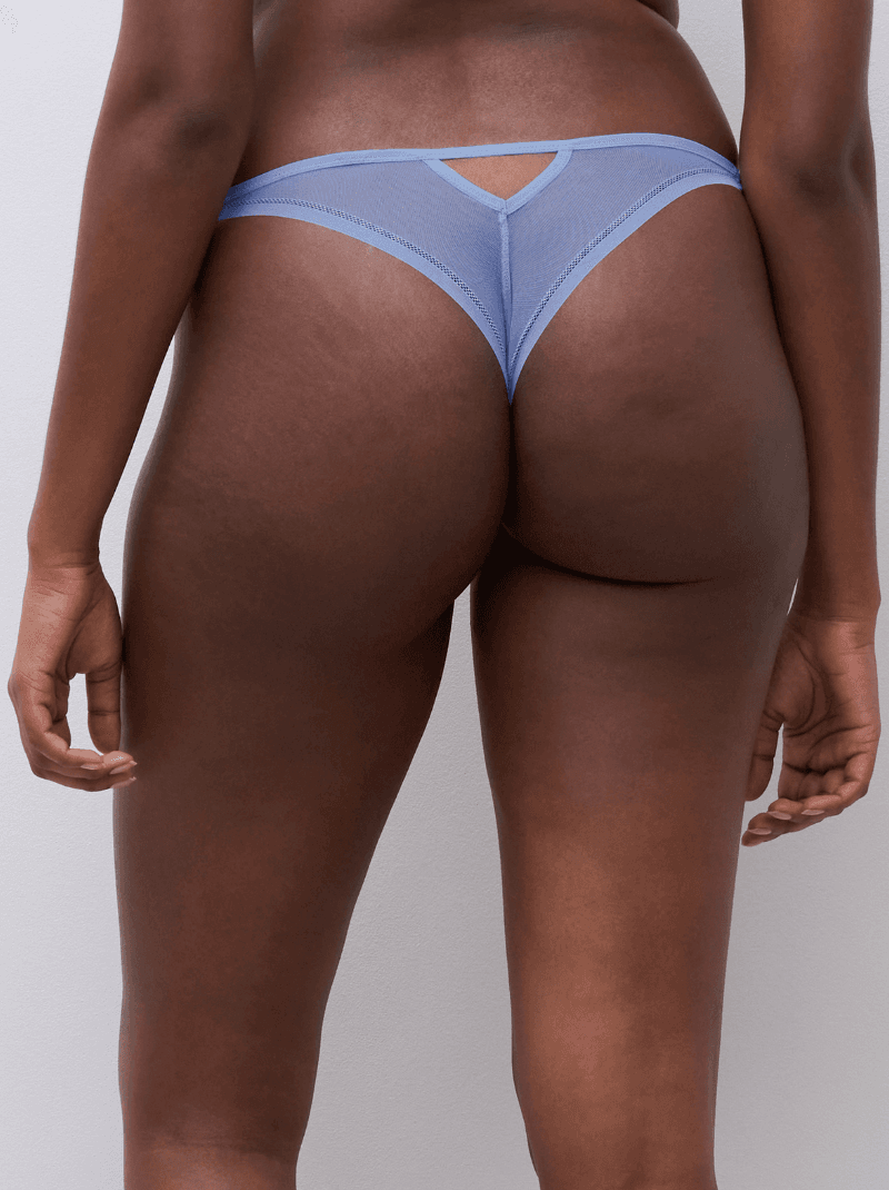 Person wearing blue mesh thong, rear view, against a plain background.