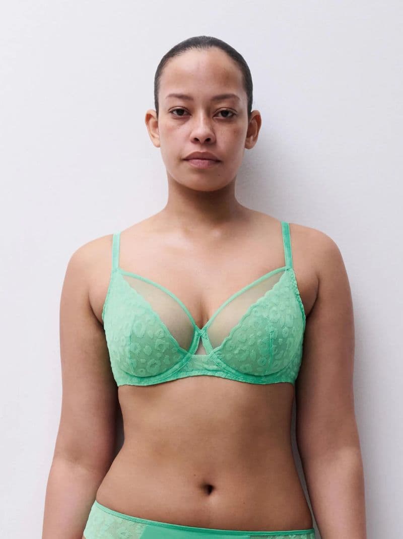 Person wearing a green patterned bra and matching bottoms, standing against a plain white background.