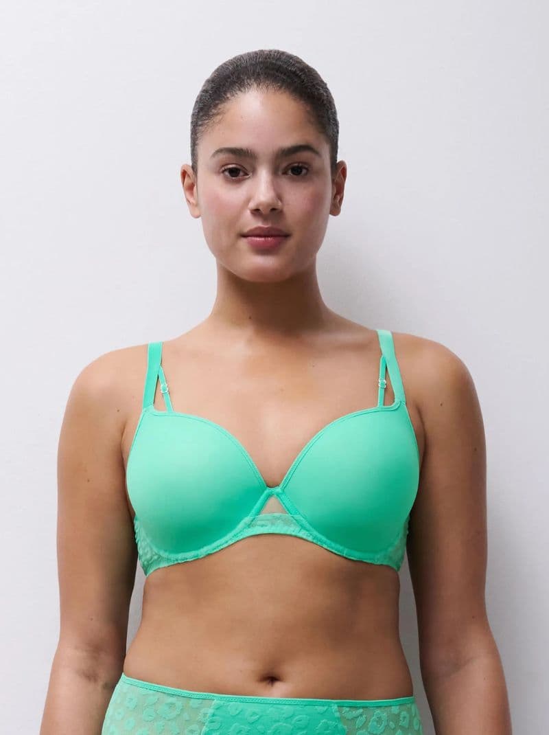 Person wearing a matching green bra and underwear, standing against a white background.
