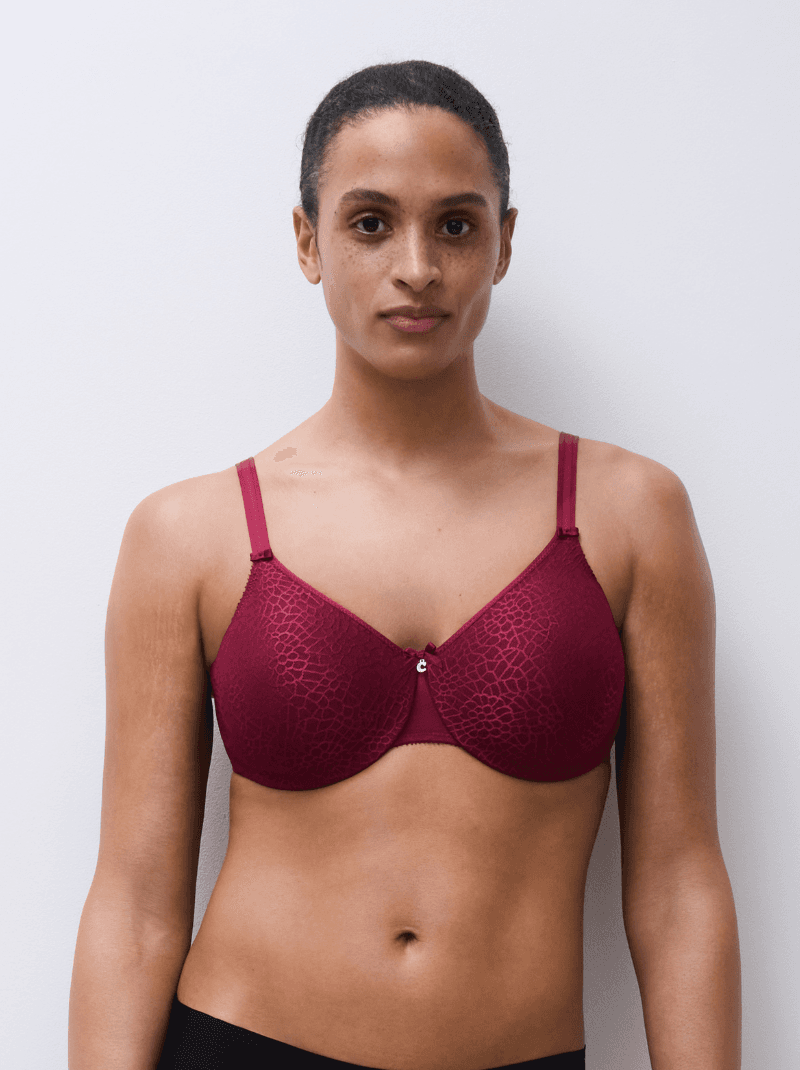 Person wearing a maroon bra with a subtle lace pattern, standing against a plain light background.