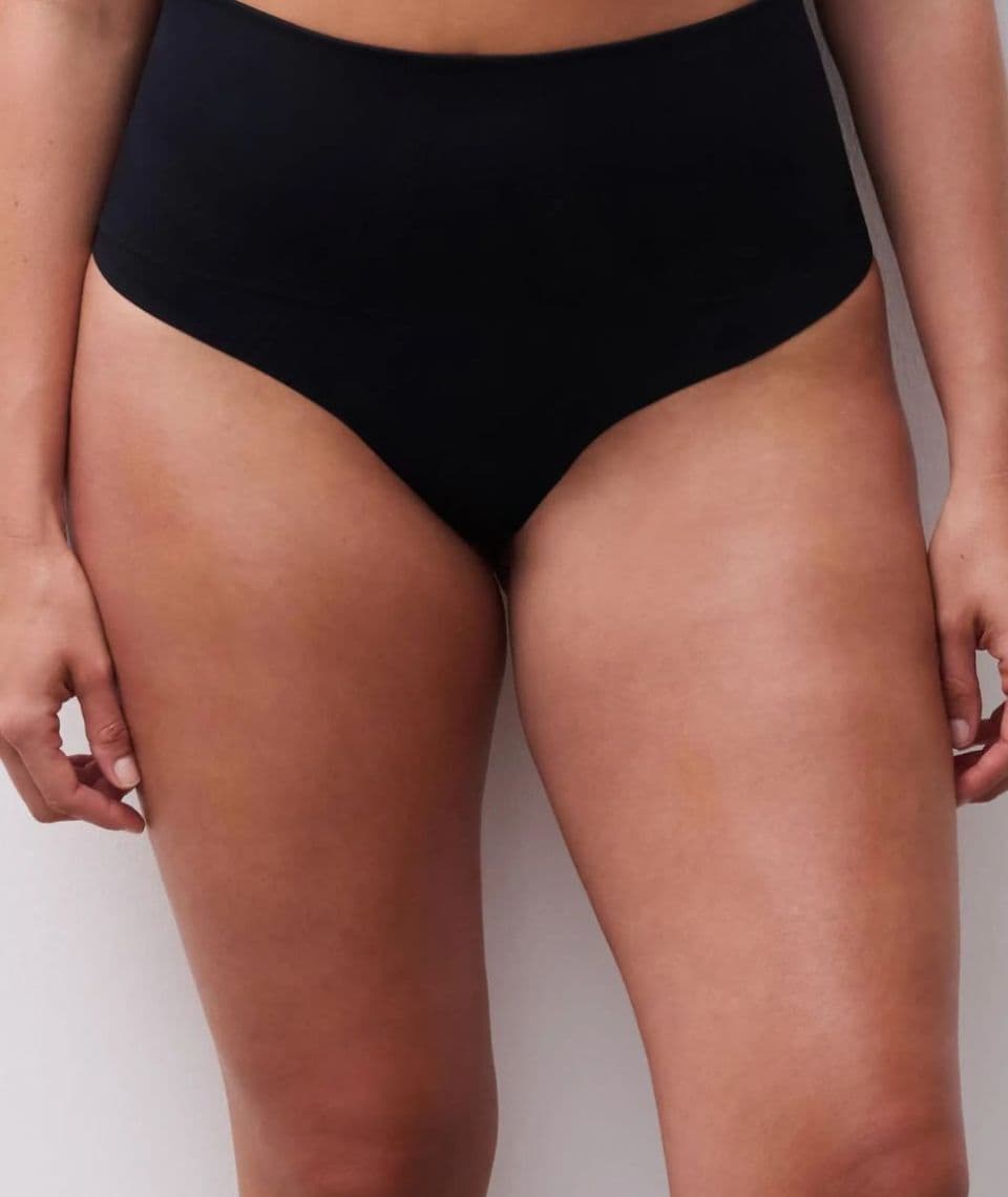 Person wearing high-waisted black underwear against a plain white background.