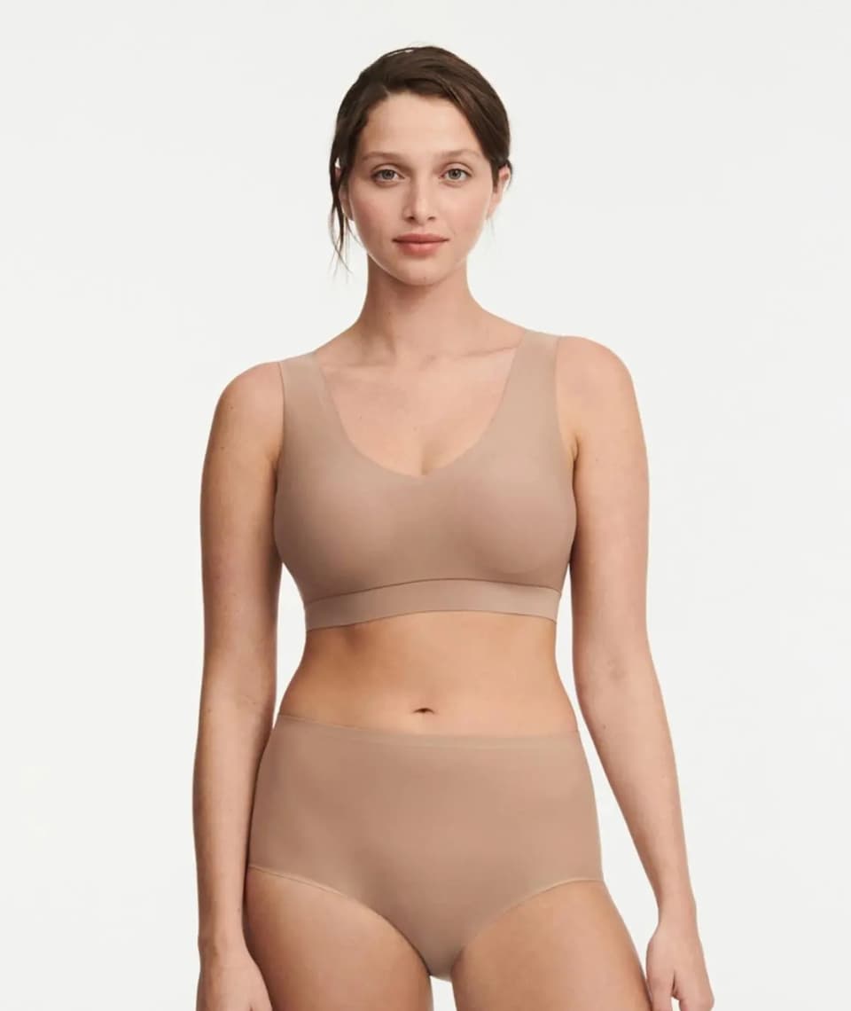 Woman in beige seamless underwear with a neutral expression on a plain background.