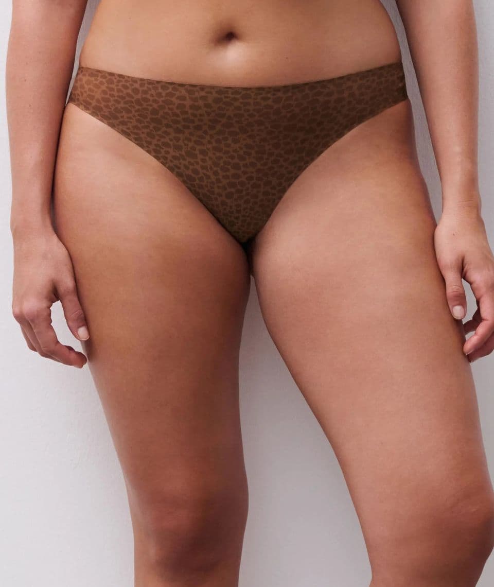 A person wearing brown leopard-print underwear, standing against a plain white background.