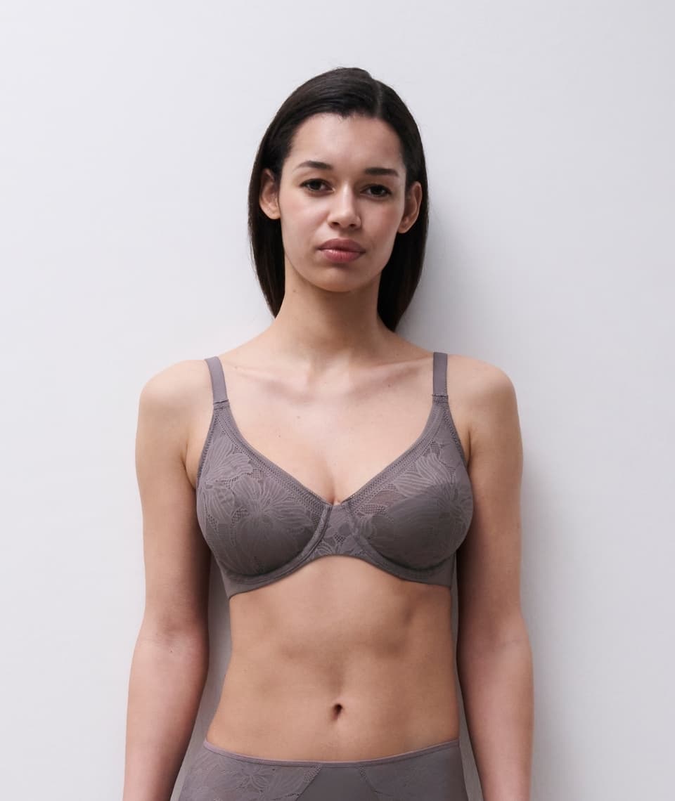 Person wearing a matching taupe lace bra and underwear set, standing against a plain background.