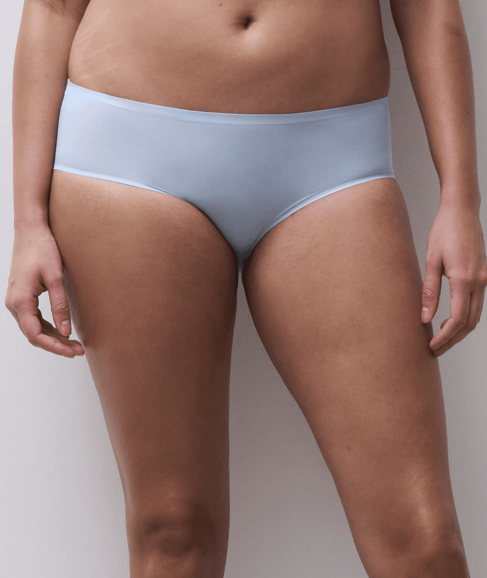 Person wearing light blue underwear standing against a neutral background.