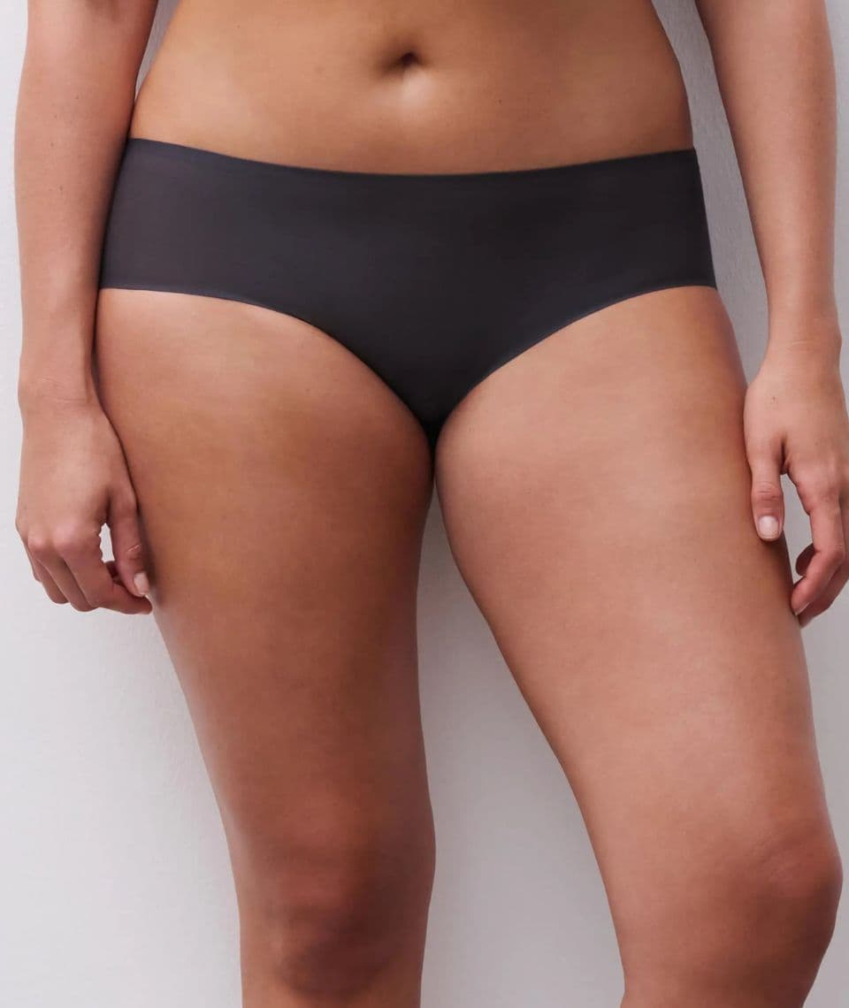 Person wearing seamless, high-waisted carbon colored underwear against a plain background. The underwear fits smoothly on the skin.