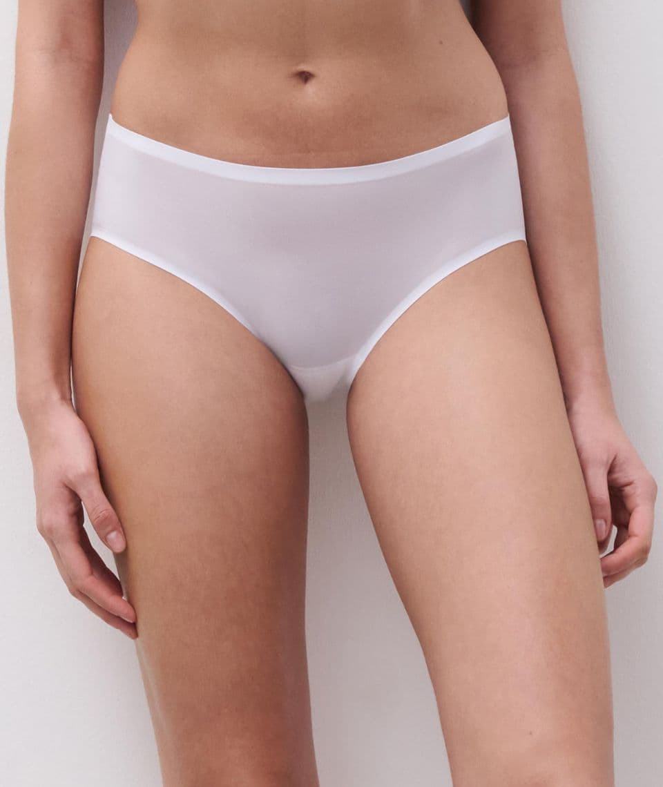 A person wearing seamless white underwear, standing against a plain background.