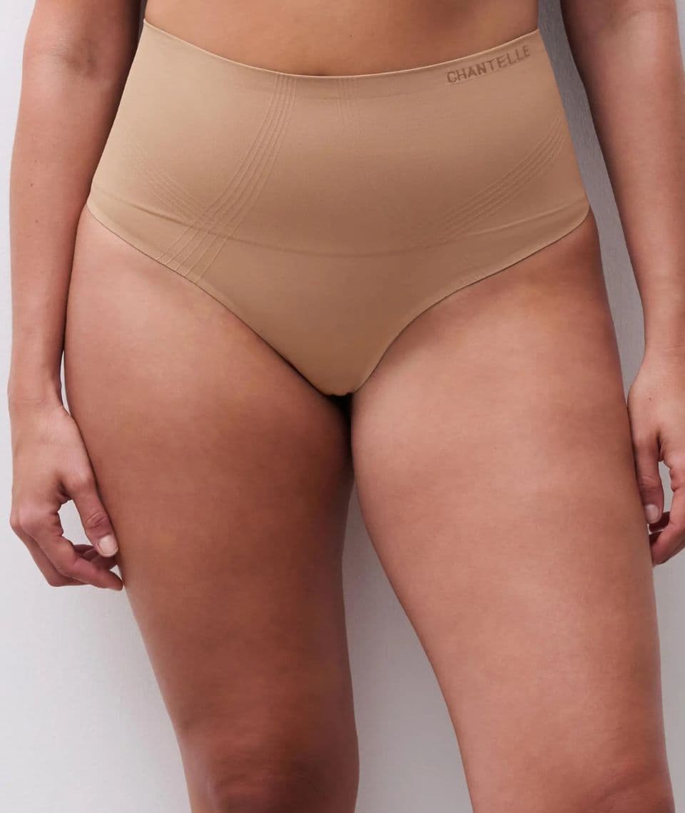 Person wearing high-waisted, nude-colored Chantelle shapewear, standing in front of a light background.