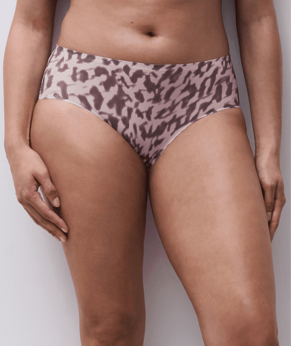 A person wearing high-waisted underwear with a brown and beige abstract pattern, showing midsection and upper thighs against a plain background.