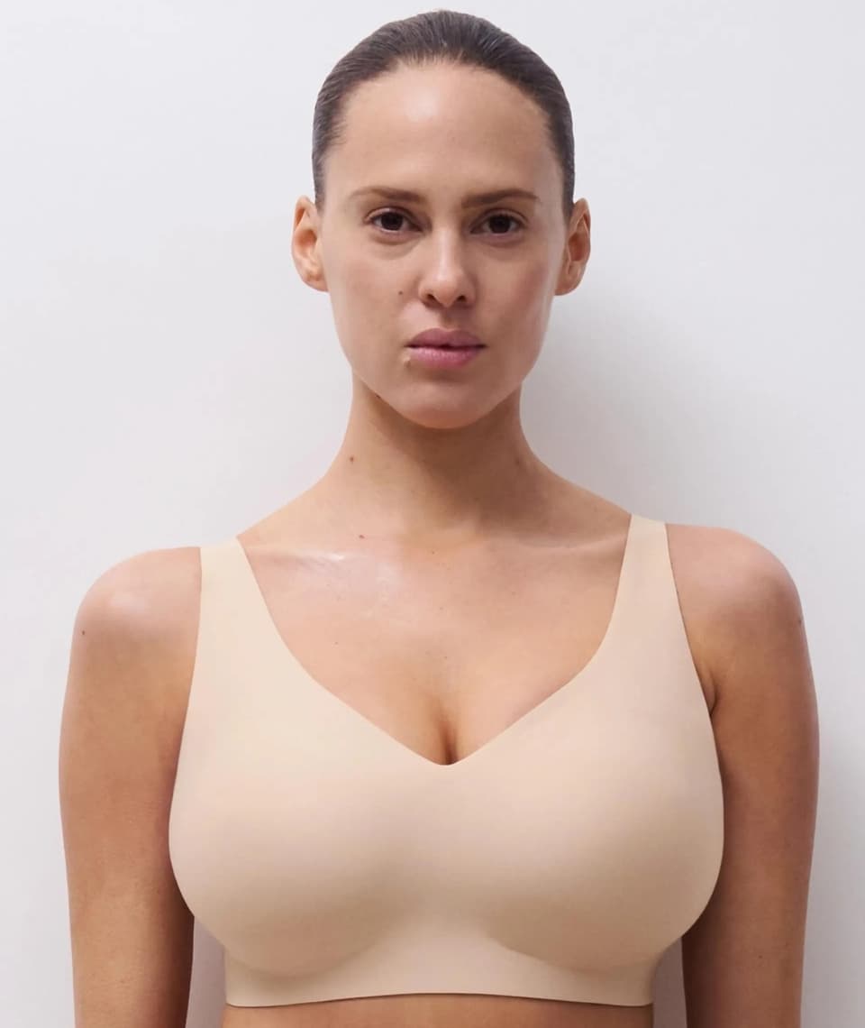 Person wearing a seamless nude-colored bra against a white background.