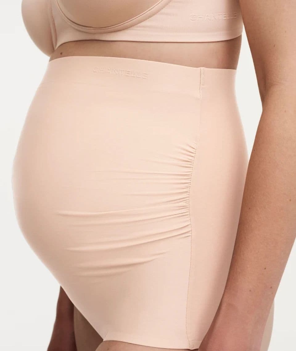 Side view of a person wearing beige seamless high-waisted underwear and a matching bra, showing a smooth fit and subtle ruching on the side.