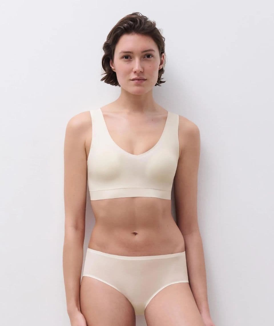 Person wearing a white seamless bralette and panties, standing against a plain white background.