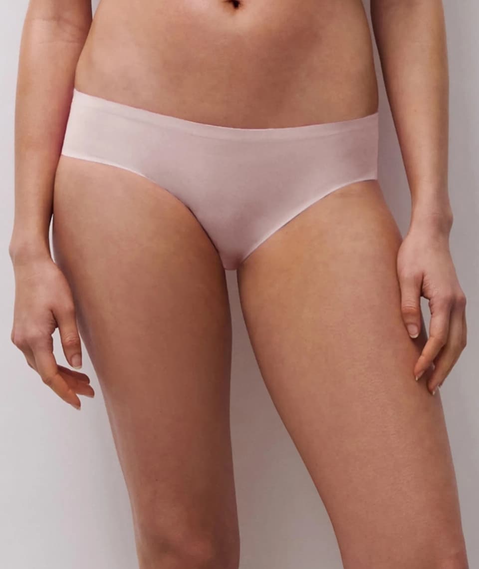Person wearing seamless, light pink underwear, shown from the waist down against a neutral background.