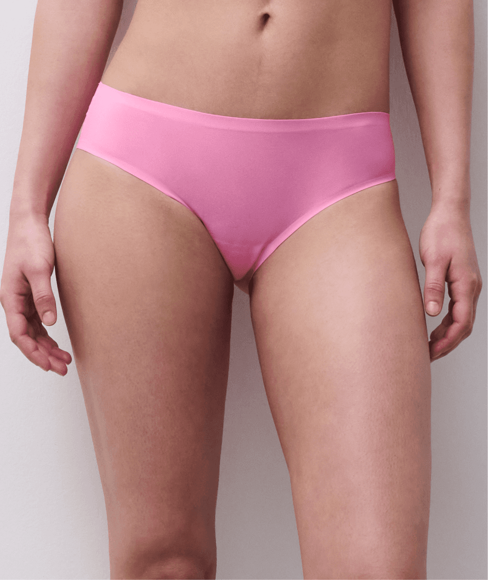 Person wearing pink underwear standing against a white background.