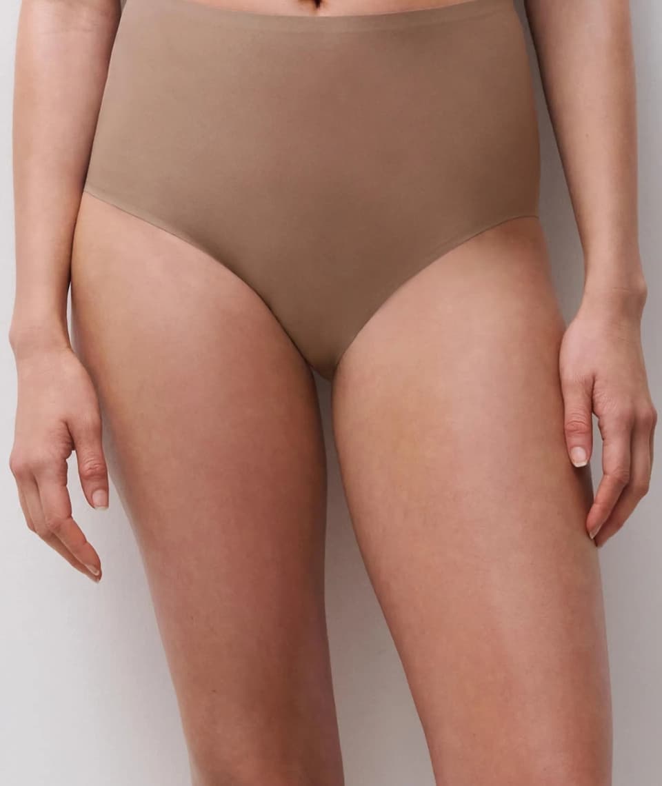 Person wearing high-waisted, cappucino colored underwear, standing against a plain background. Only the midsection and upper legs are visible.