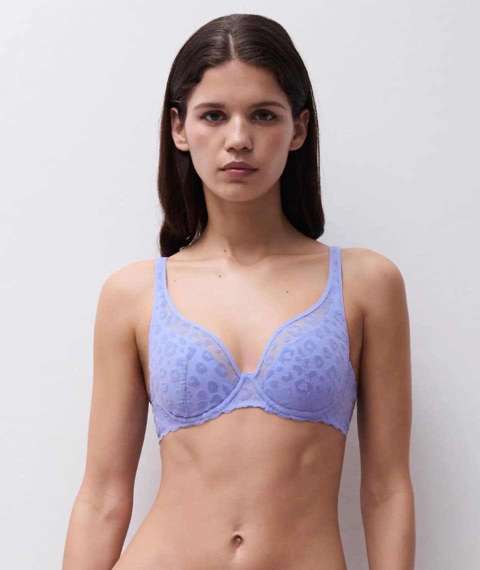 Person wearing a lila leopard patterned bra infront of a grey wall