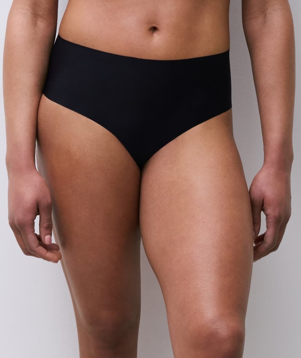 Person wearing high-waisted black underwear, shown from waist to upper thighs against a plain background.