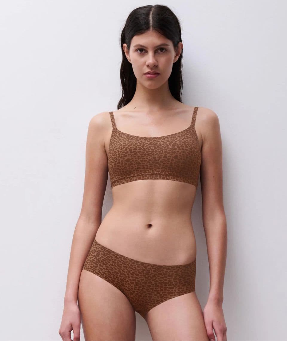 Woman wearing a brown leopard-print bra and panties against a plain white background.