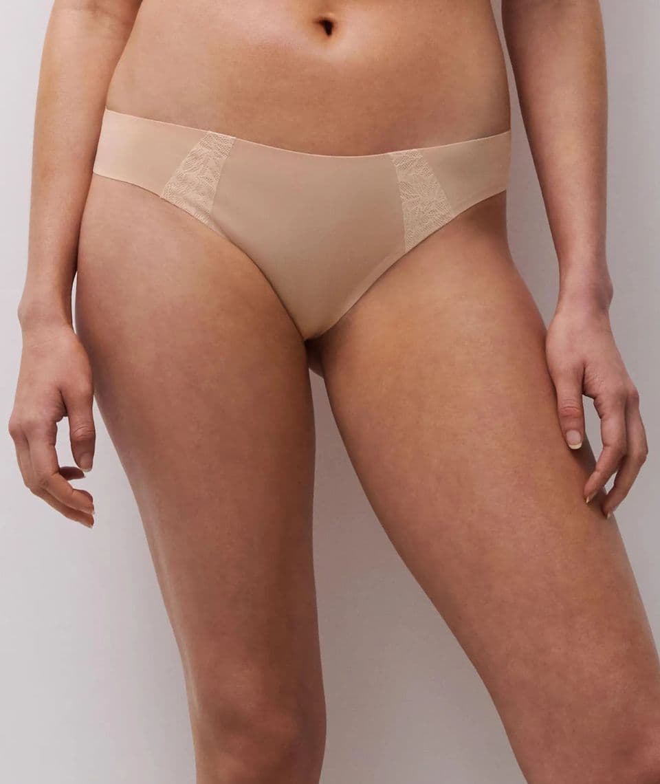 Person wearing nude-colored seamless underwear with lace details on the sides.