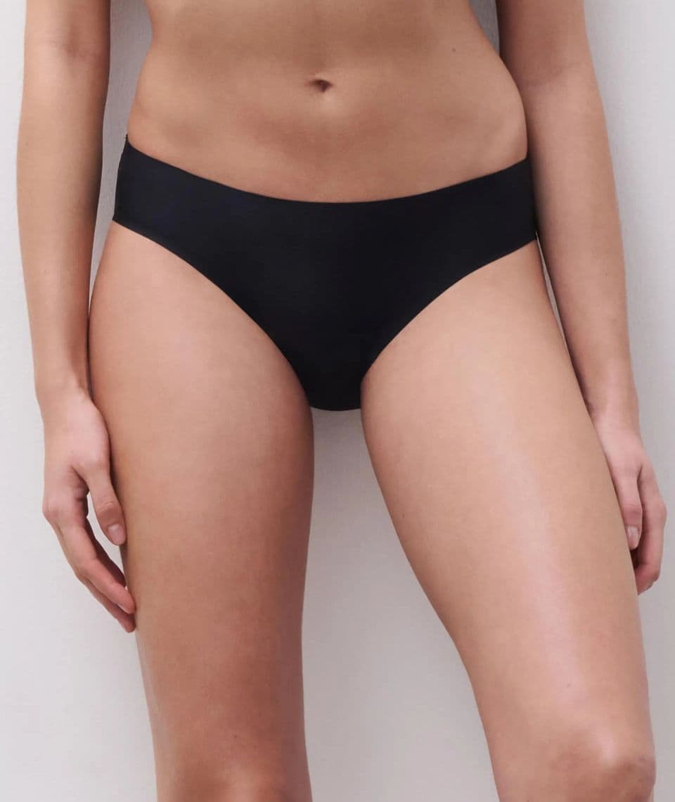 Person wearing black bottoms, standing against a plain background.