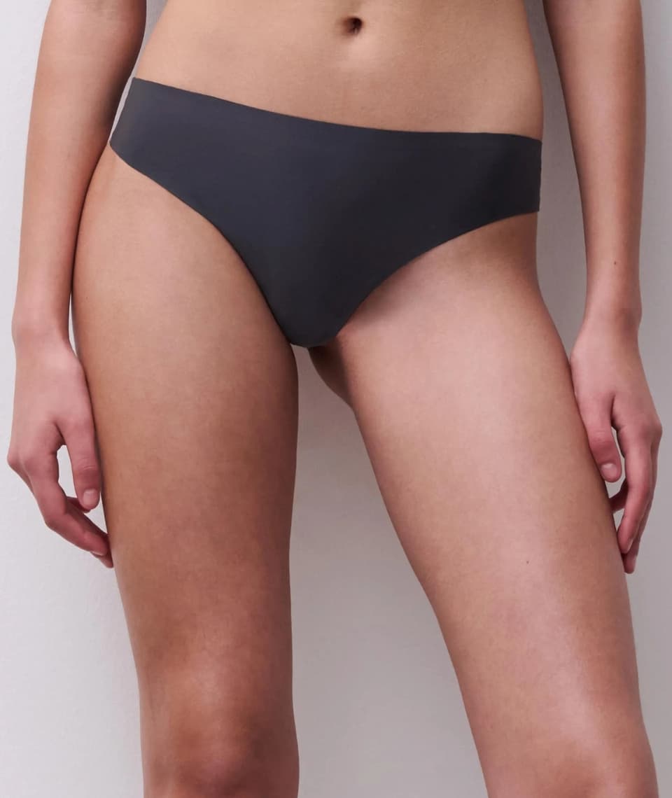 Person wearing dark gray bottoms against a white background, focusing on the lower torso and hips.