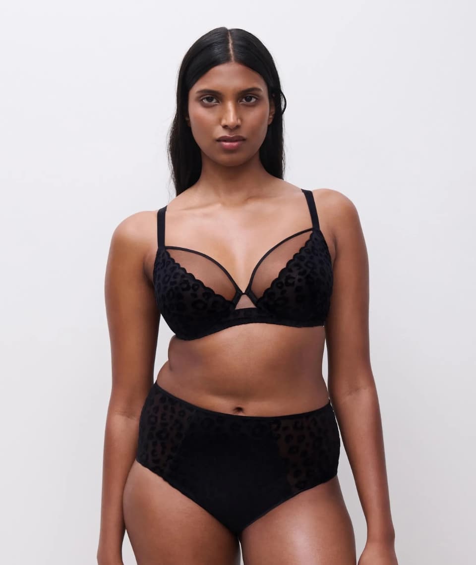 Person wearing a black textured lingerie set against a plain white background.