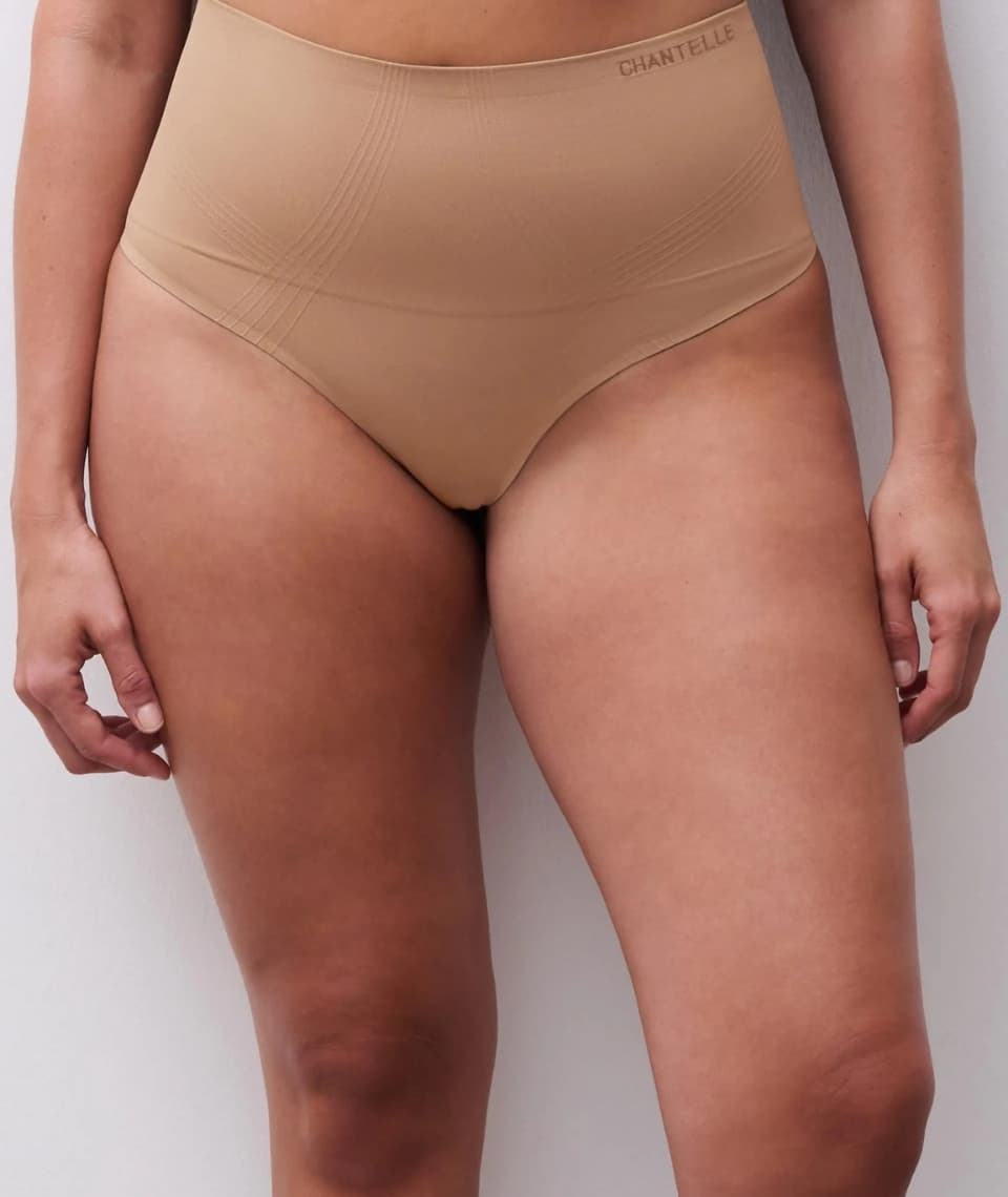 Person wearing high-waisted teracotta colored underwear, standing against a light background. The brand "Chantelle" is visible on the waistband.