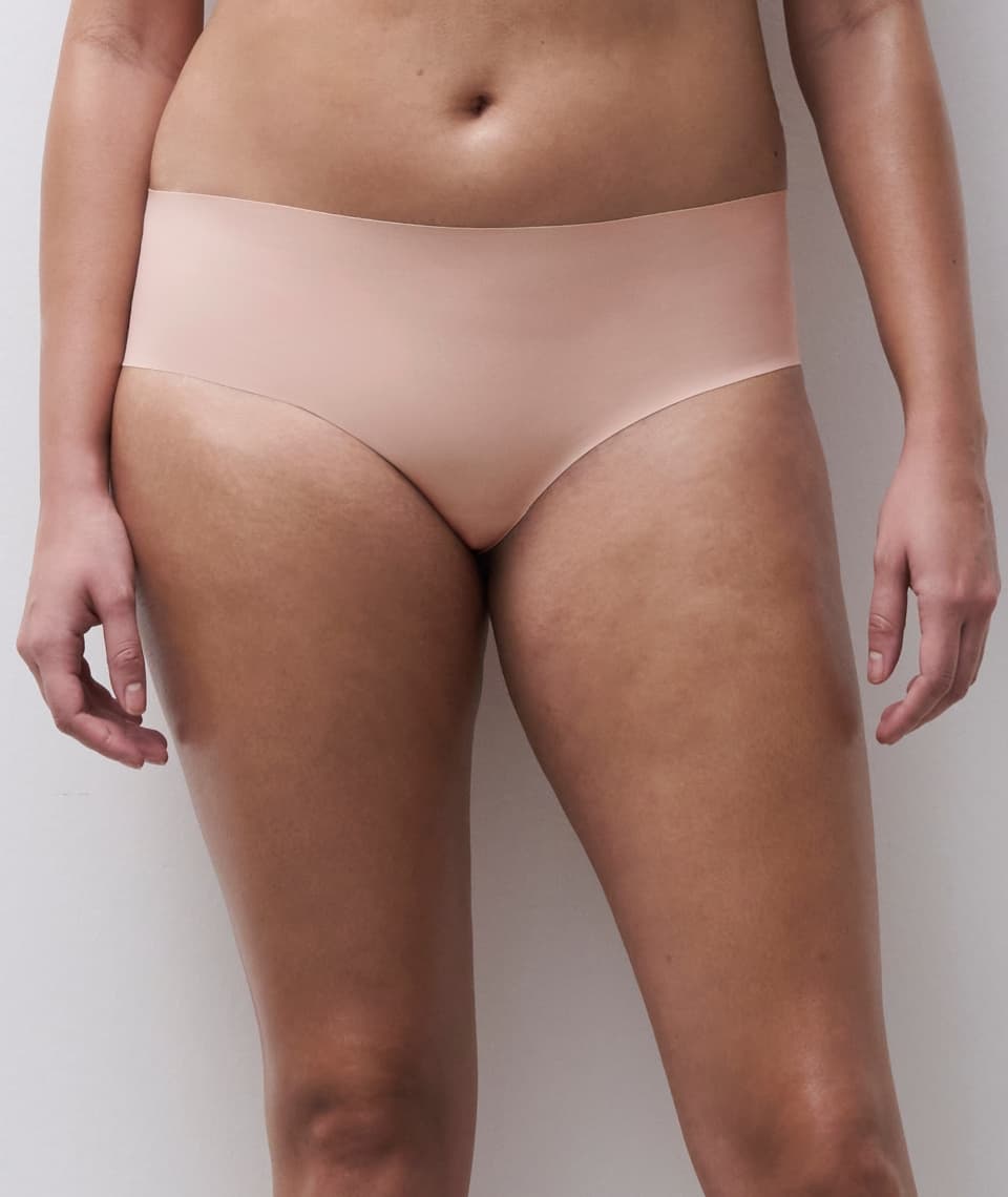 A person wearing seamless soft pink underwear, shown from the waist to mid-thigh, against a plain background.