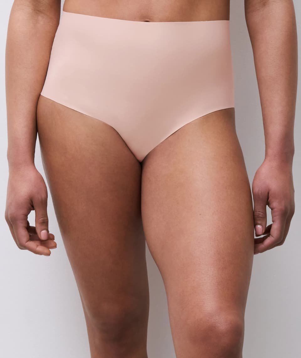 Person wearing seamless, high-waisted  underwear against a plain background.