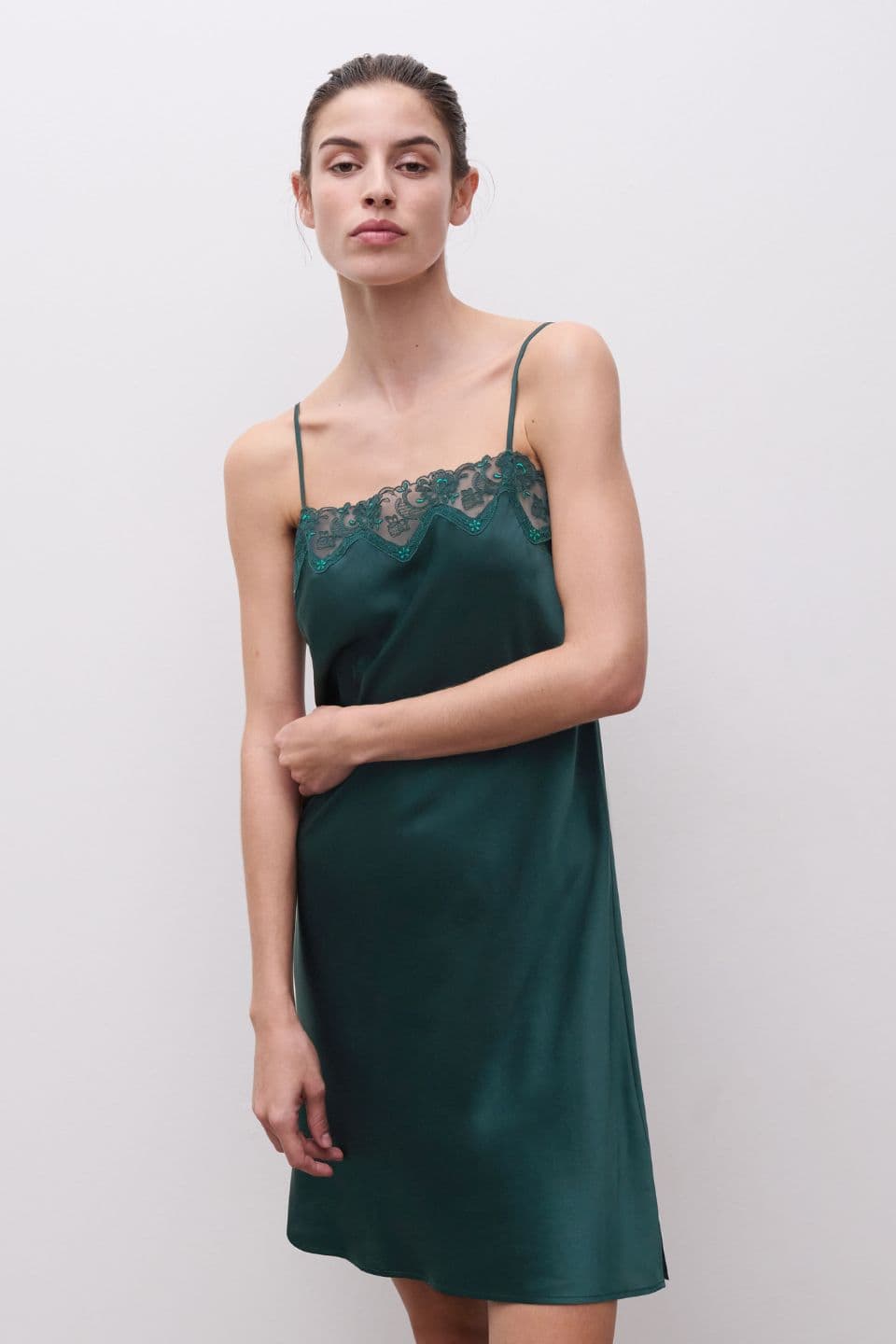 A woman is seen wearing a nightdress in dark green.