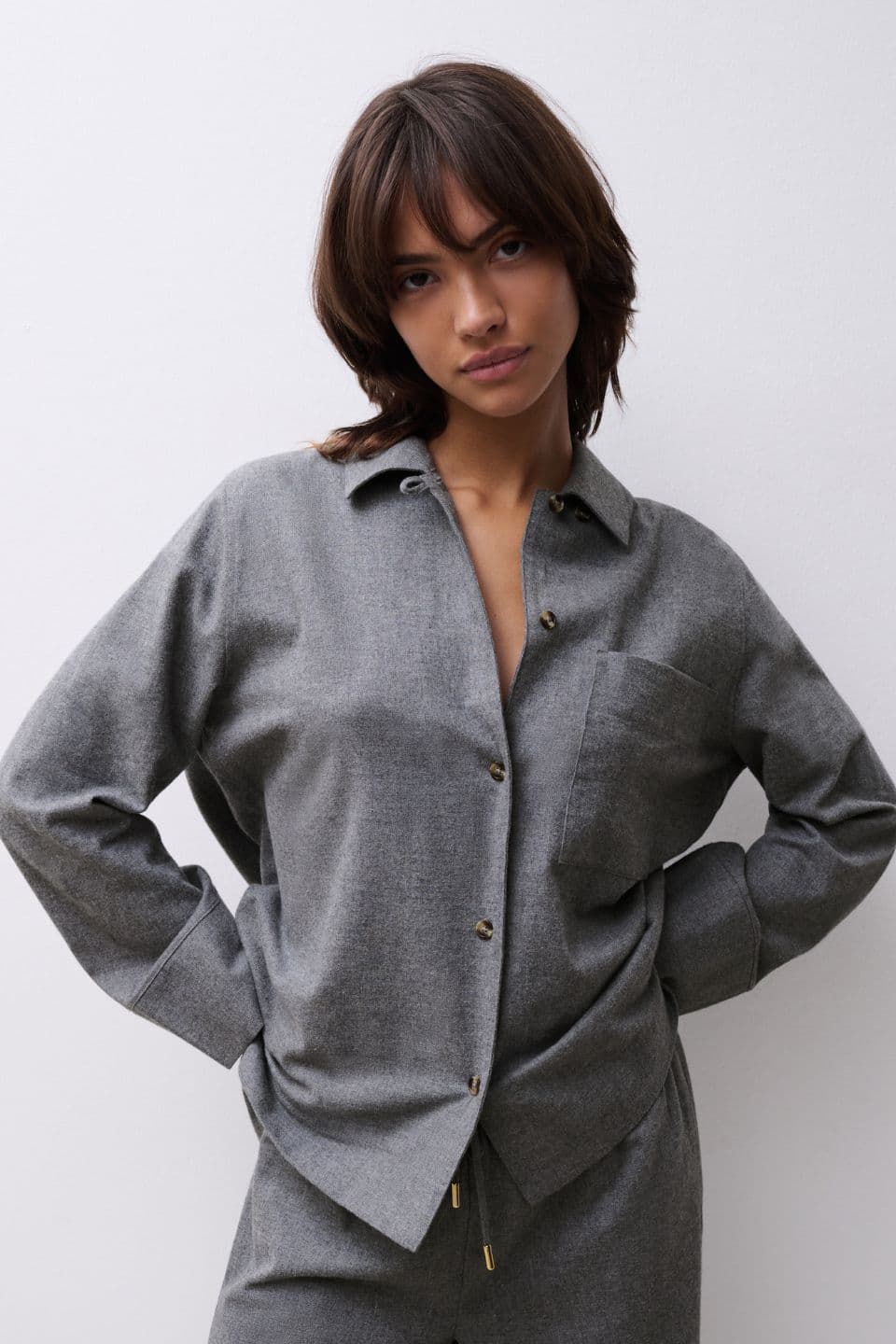 The image features a woman in a relaxed grey shirt