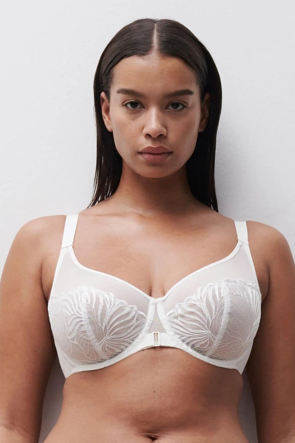 The image shows a woman wearing an underwired bra with delicate embroidered cups, creating an elegant and refined lingerie look